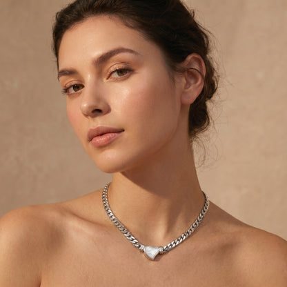 woman wearing silver heart pendant choker necklace minimalist elegant jewelry close-up